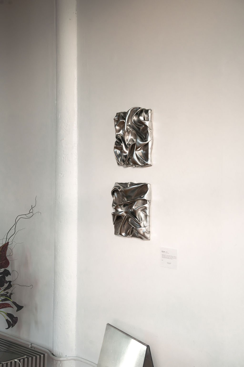Diptyque d’œuvres argentées sur un mur blanc