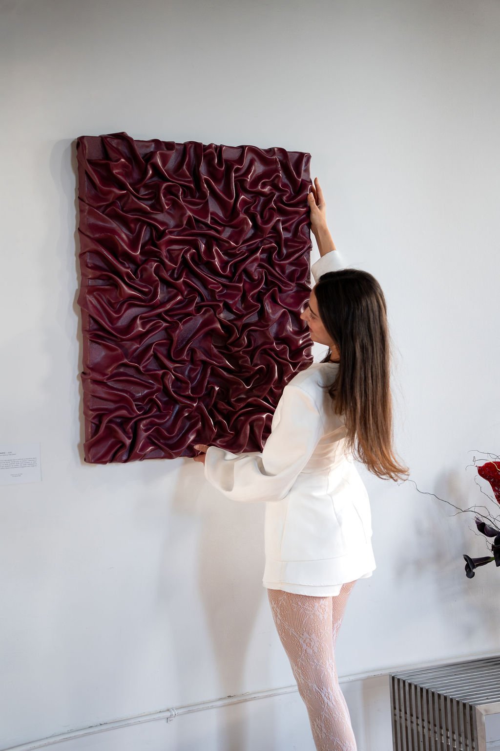 Elya ajustant une œuvre bordeaux